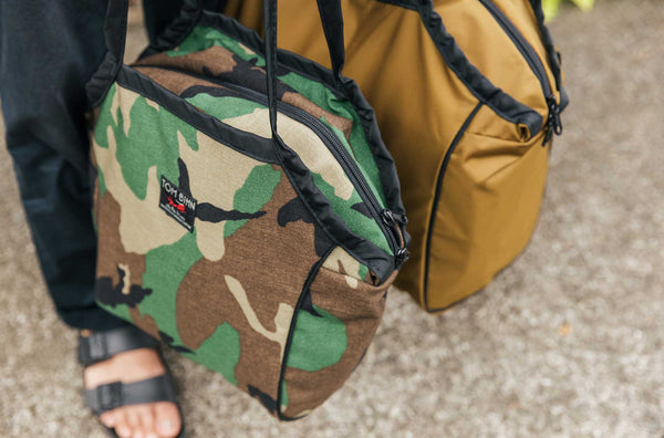 Person standing and carrying the Zip-Top Shop Bag, Size Small, in Beaver Camo.